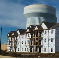 Big halfway built building with a huge water tower in the background