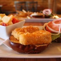 Hamburger-looking bun and food next to lettuce, tomato and other food