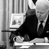 Biden at his desk signing something