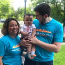 A young couple and the man holding a baby