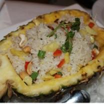 Pineapple cut in half with lots of rice and vegetables inside