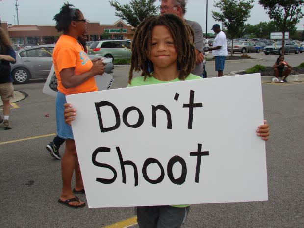 Boy holds sign that says Don't Shoot