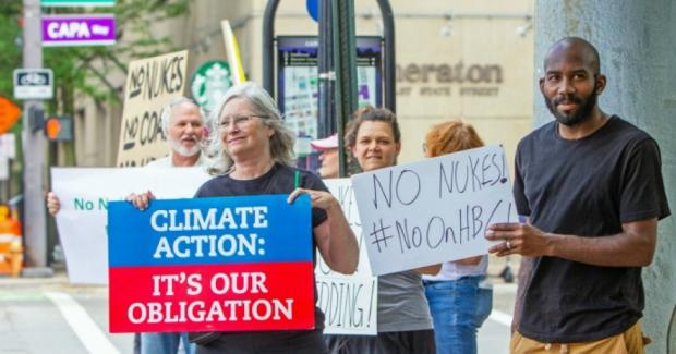 Woman holding a sign saying Climate Action It's our Obligation