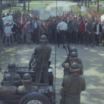 MIlitary looking men facing off a group of people