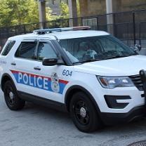 Large white SUV with Police in letters on the side and lights on top