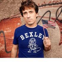 Young white man with brown hair and a Bexley T-shirt holding a small American flag