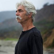 white haired man with moustache standing outside hair blowing in wind