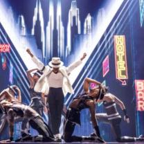 Actor playing Michael Jackson with dancers around on stage