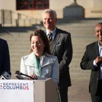 Woman speaking at podium outside at press conference