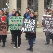 People outside City Hall holding signs 