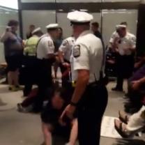 Policeman throwing a woman out of her wheelchair